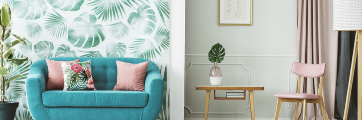 Turquoise sofa by leaves wallpaper
