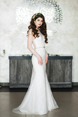 Portrait of a beautiful bride. Wedding make-up. Volume hairstyle. The curls. Brunette in a beautiful interior waiting for the groom