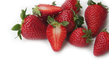 Whole and half strawberries isolated on white background