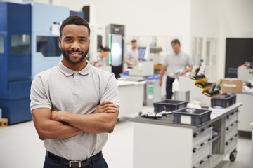 Fototapeta premium Portrait Of Male Engineer On Factory Floor Of Busy Workshop