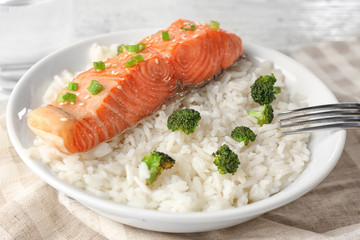 Fish fillet served with rice and broccoli in plate
