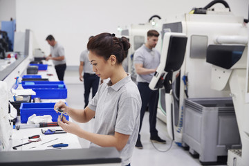 Female Engineer Quality Controlling Components In Factory