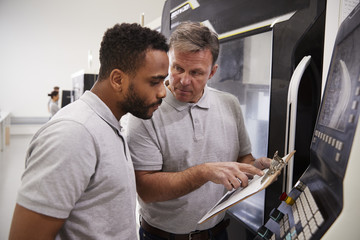 Engineer Training Male Apprentice To Use CNC Machine In Factory