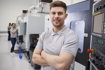 Portrait Of Male Engineer Operating CNC Machinery In Factory