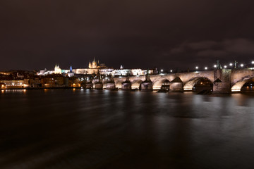 The Charles Bridge in Prague with the castle in the background lit up at night