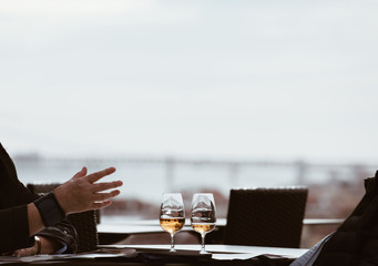 Senior peoples discussing and drinking white wine in Lisbon with amazing panorama if the capital of Portugal .