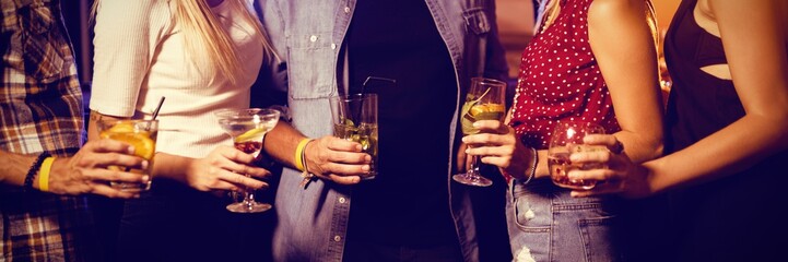Mid section of friends holding drinks