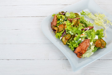Vegetable salad with veal and cucumber. Top view. On a wooden background. Copy space.