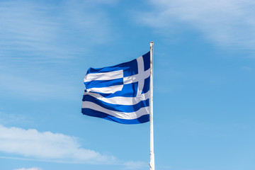 Obraz premium Flag of Greece on flagpole against the blue sky