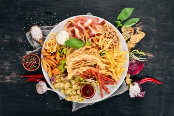 A selection of snacks for beer. Chips, sausage, cheese. Top view. On a wooden background. Copy space.