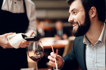 Meeting with chinese businessmen in restaurant. Waiter is pouring wine.