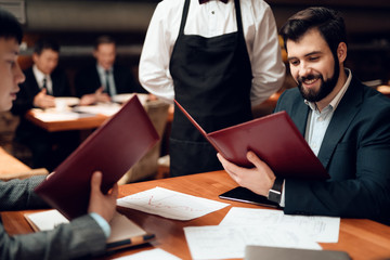 Meeting with chinese businessmen in restaurant. Two men are making order.