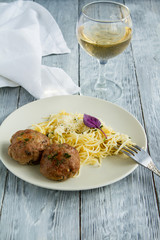 Hearty lunch from pasta spaghettii and a glass of white wine in a restaurant