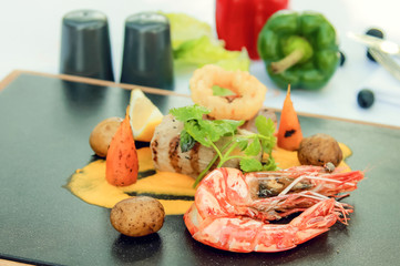 Meat and grilled shrimps on plate. Seafood and meat mix
