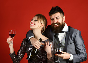 Couple in love holding glasses on red background