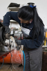 Fototapeta na wymiar Girl worker in motorcycle repair shop