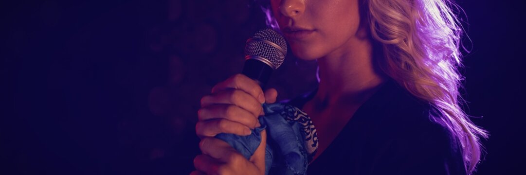 Close up of beautiful female singer with microphone - Powered by Adobe