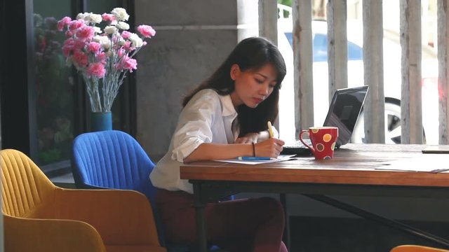 asian woman freelance working on destop computer in home office