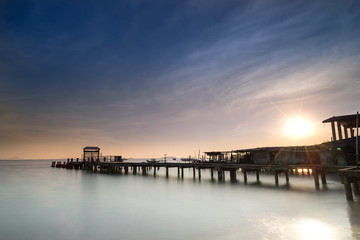 Fototapeta na wymiar peaceful morning with wood dock in sea and sunrise star