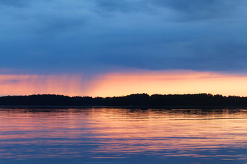 Sunset on the Vuoksa lake. It is small rain on the horizon. 
