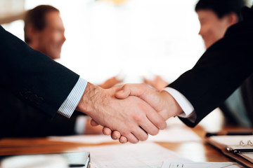 Close up meeting with chinese businessmen in restaurant. Men are shaking hands.