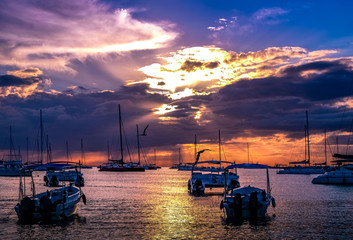 Boats in a beautiful blue and purple sunset at beach in the Caribbean Sea.
