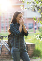 Woman blowing nose because of spring pollen allergy