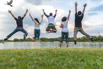 Teamwork success concept with group of jumping friends in the public park.   Team work Concept