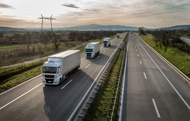 Fototapeta Caravan or convoy of trucks in line on a country highway obraz