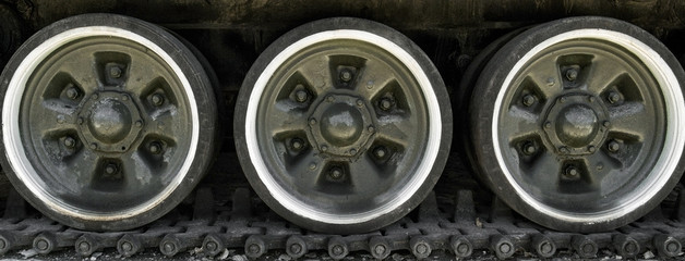 Obraz premium Old tank rollers. Old tank tracks and rollers. Closeup of tracks and rollers of the tank. Military museum in the open air