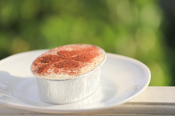Saint Patrick's day dessert. Banoffee sweet chocolate powder dressing as four leaves of clover. Symbol of lucky on tasty dessert on white plate