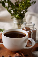 Coffee cup, jar with coffee beans, cookies over rustic background, selective focus, close-up, top view