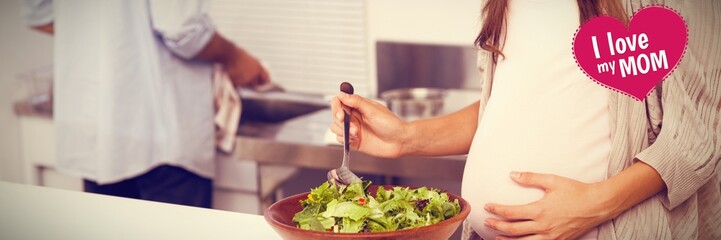 Composite image of pregnant woman mixing a salad in the kitchen