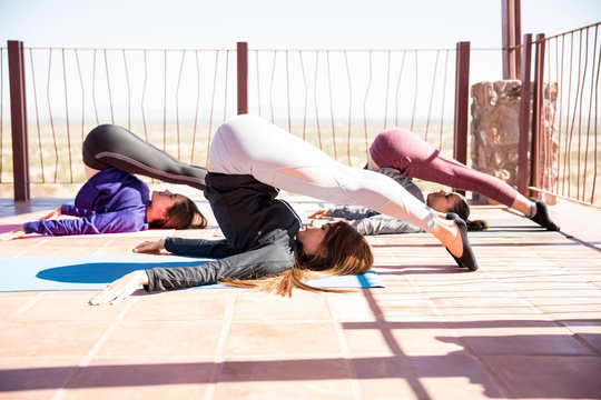 Group of women working out plow yoga pose - Powered by Adobe