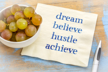 Dream, believe, hustle, achieve - text on napkin