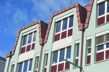 Obraz premium Fassade eines modernen Gebäudes mit Dachabschluss aus rot beschichtetem Metall