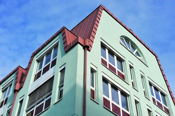 Fassade eines modernen Gebäudes mit Dachabschluss aus rot beschichtetem Metall