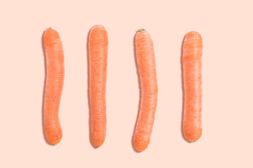 top view of carrots in order on orange toned background