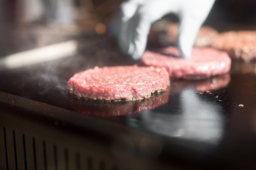 Hamburger cutlet frying on pan.Natural meet loaf pieces cooking in the kitchen.Burger sandwich meat being cooked with a lot of white smoke from a fat and oil.