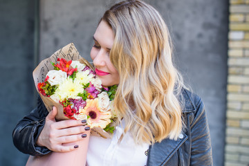 A woman of plus size, American or European appearance walks in the city enjoying life. A young lady with excess weight, stylishly dressed in jacket at the center of the city. Natural beauty 