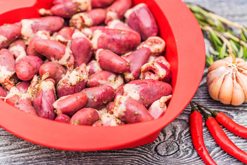 Fresh raw chicken hearts with pepper in bowl