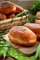 Golden fried patties on a wooden board surrounded green onion and tarragon. Russian cuisine meal