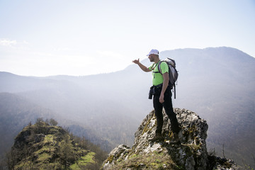 Fototapeta premium Successful young hiker resting in the forest and enjoying his adventure time