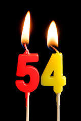 Burning candles in the form of 54 fifty four (numbers, dates) for cake isolated on black background. The concept of celebrating a birthday, anniversary, important date, holiday, table setting