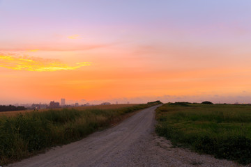 Fototapeta na wymiar Empty dirt road to sunset