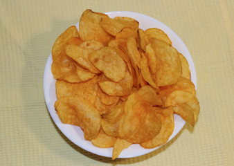 Potato chips on a white plate, fast food.