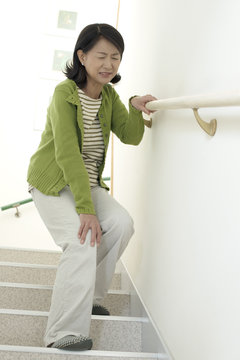 階段を降りるシニア女性