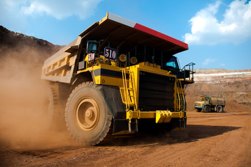 shipping. mining, delivery, transportation, loading, dump truck, truck, huge, heavy. Mining dump truck transports rock, iron ore along the side of the quarry.