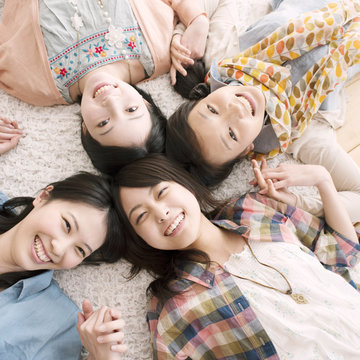 手をつなぎ微笑む4人の女性