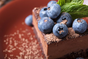 Chocolate cake with blueberries and mint .